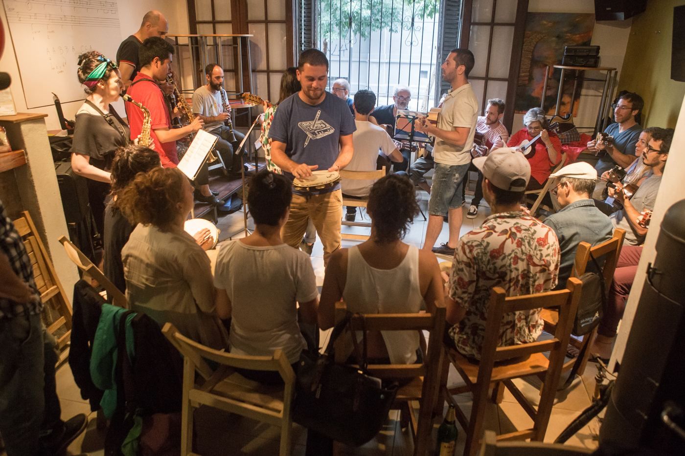 Encuentro del Núcleo: un grupo grande tocando en ronda dentro de una sala