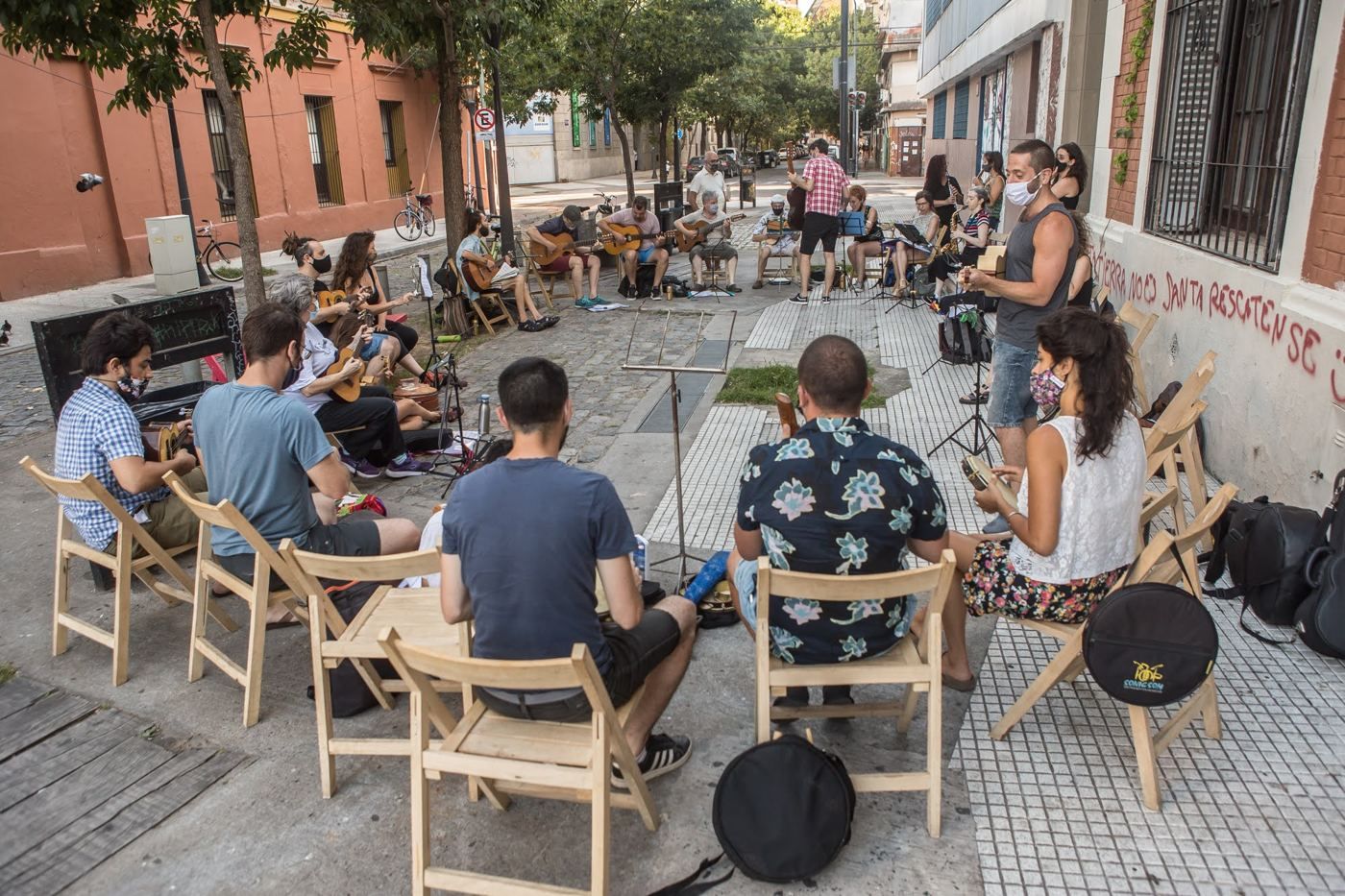 Roda en la vereda: músicos sentados en círculo